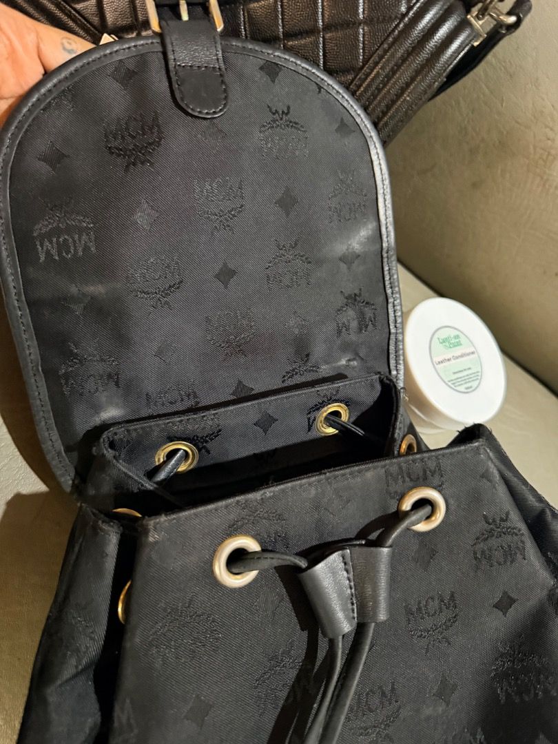 Black MCM Monogram Nylon Backpack with Front Pockets (Category: Backpacks) located in Manila. Submitted by _outofthecloset. (Listing ID 1465421748, Image 3). Description: - black MCM monogram backpack - Secure drawstring closure with buckled flap and magnetic snap - Two exterior front utility pockets with MCM logo plate - Elegant gold-tone hardware throughout - Fabric-lined interior with a convenient zippered pocket - Features a sturdy top handle