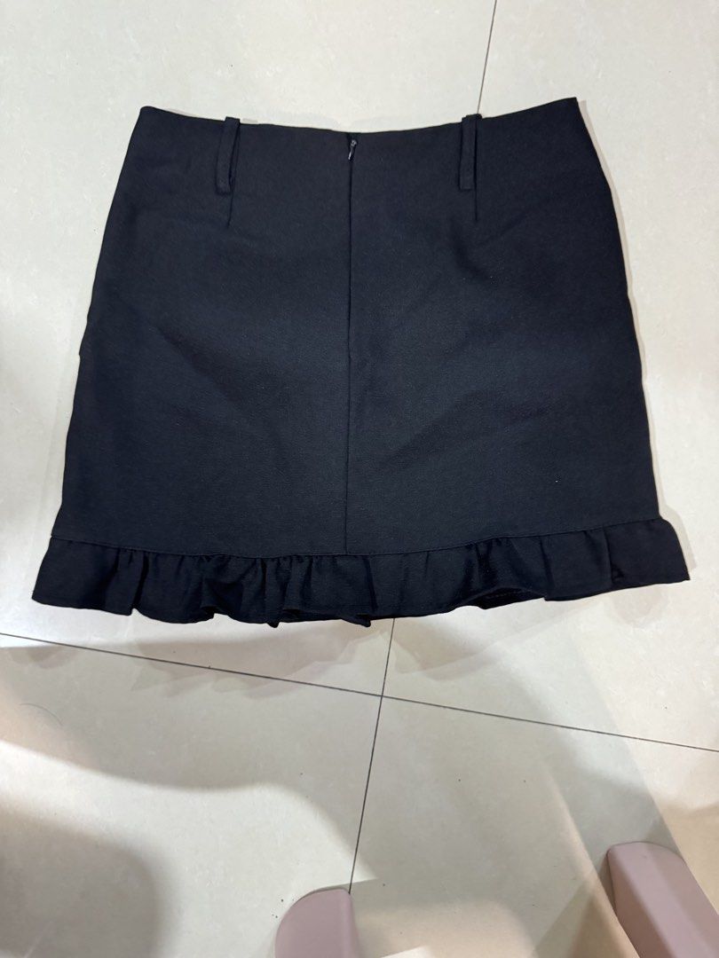 Black Ruffle Hem Mini Skirt with Belt Loops (Category: Skirts) located in Quezon City. Submitted by sweetlyluxe (Listing ID 1465492284, Image 2). Description: - Color: Classic black (goes with everything) - Design: Cute ruffled hem at the bottom - Comfort: Built-in shorts underneath for extra coverage - Details: Two front belt loops on the waistband - Closure: Secure zip closure at the back - for office, corporate.