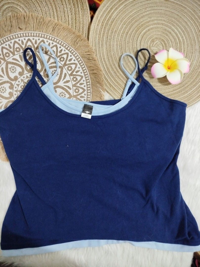 Blue camisole with built-in light blue inner layer (Category: Sleeveless) located in Quezon City. Submitted by plus4lessshop (Listing ID 1465441063, Image 1). Description: - Color: Navy blue with contrasting light blue inner layer - Details: Scalloped white trim along the neckline - Straps: Thin, adjustable straps on both inner and outer layers - Design: Unique double-layered style - Fit: Comfortable fabric, perfect for casual wear and layering.