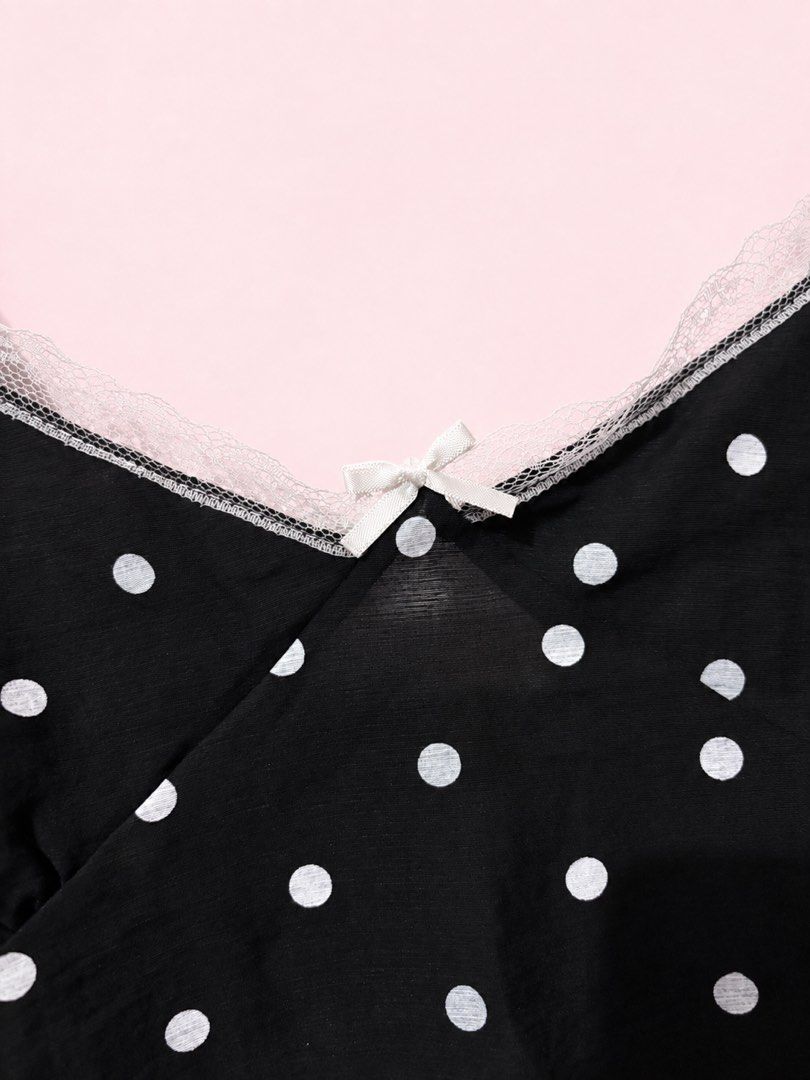 Brandnew BKK Tops (Category: Blouses) located in Manila. Submitted by r.audrey_s (Listing ID 1465487083, Image 2). Description: - Color/Pattern: Black with all-over white polka dots - Design: V-neckline with delicate lace trim and a cute center bow - Straps: Thin, ruffled straps for a feminine look - Fabric: Lightweight and breathable - Styling: Great for layering or wearing on its own.