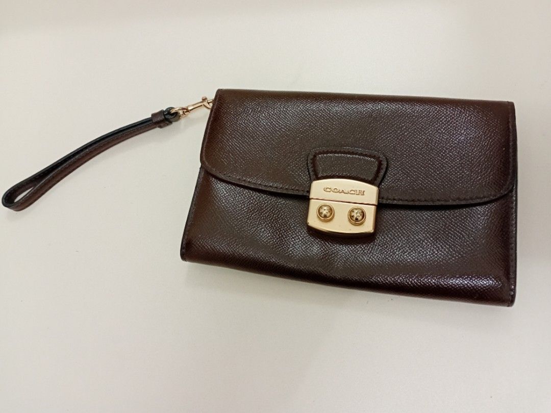 BROWN COACH MEDIUM WALLET w/ WRISLET (Category: Luxury Bags & Wallets) located in Manila. Submitted by eriiicaspage (Listing ID 1465435101, Image 2). Description: PreOwned Lighlty Used WellUsed BROWN COACH WALLET w/WRISLET STRAP MEDIUM Dark brown textured leather with contrasting dark red interior lining - Hardware: Gold-tone push lock closure and lobster clasp - Strap: Includes a removable matching wrist strap - Features: Compact size, ideal for