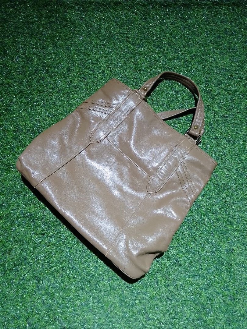 Brown Faux Leather Tote Handbag (Category: Tote Bags) located in Manila. Submitted by patrickjos06722 (Listing ID 1465501285, Image 1). Description: - Color: Brown - Design: Sturdy top handles with front stitched panel details and gold-tone hardware - Interior: Dark fabric lining with a secure zippered middle compartment divider - Structure: Flat, structured base panel helps the bag stand upright - Capacity: Spacious main compartment with plenty 