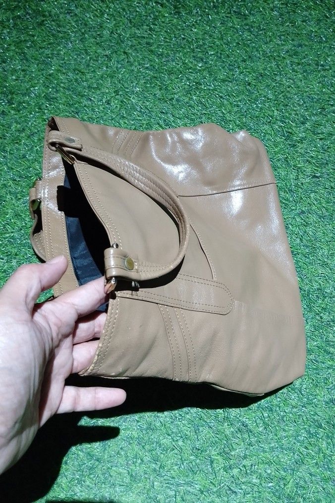 Brown Faux Leather Tote Handbag (Category: Tote Bags) located in Manila. Submitted by patrickjos06722 (Listing ID 1465501285, Image 3). Description: - Color: Brown - Design: Sturdy top handles with front stitched panel details and gold-tone hardware - Interior: Dark fabric lining with a secure zippered middle compartment divider - Structure: Flat, structured base panel helps the bag stand upright - Capacity: Spacious main compartment with plenty 