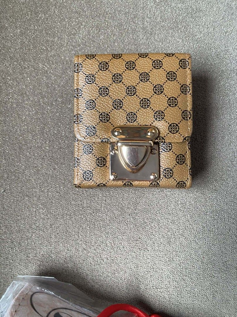 Brown pattern card holder wallet with clasp (Category: Wallets & Card holders) located in Zaragoza. Submitted by sherree1281 (Listing ID 1465383000, Image 1). Description: - Stylish brown wallet with a modern geometric pattern - Secure gold-tone lock clasp closure - Spacious accordion-style card holder with multiple slots - Compact size, ideal for cards and cash - Meetup or shipping options available - Send a message for inquiries.