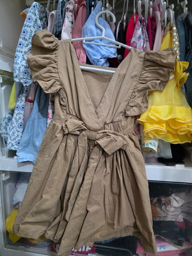 Brown Ruffle Sleeves Dress (Category: Babies & Kids Fashion) located in Taguig. Submitted by jeaniper (Listing ID 1465432358, Image 2). Description: - Color: Brown - Design: Square neckline, short ruffle sleeves, and flared gathered skirt - Back Details: Criss-cross straps with an adjustable tie bow - Material: Soft and comfortable everyday fabric - Styling: Easy to match with different shoes and cardigans for any casual occasion.