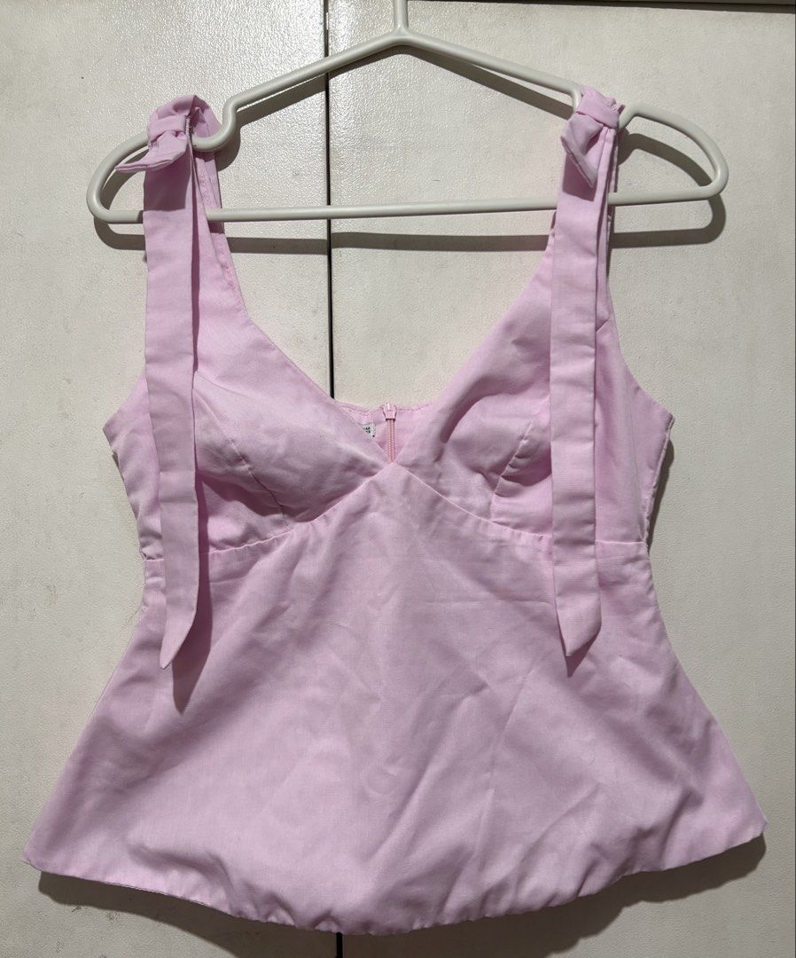 BSCO Celeste Pink V-Neck Peplum Top (Category: Sleeveless) located in Pasay City. Submitted by kio__ (Listing ID 1465434357, Image 1). Description: gorgeous and pastel, this top is baby pink and features bows on the straps and a flattering peplum silhouette. very versatile, looks amazing with both skirts and jeans! do contact me if interested. .