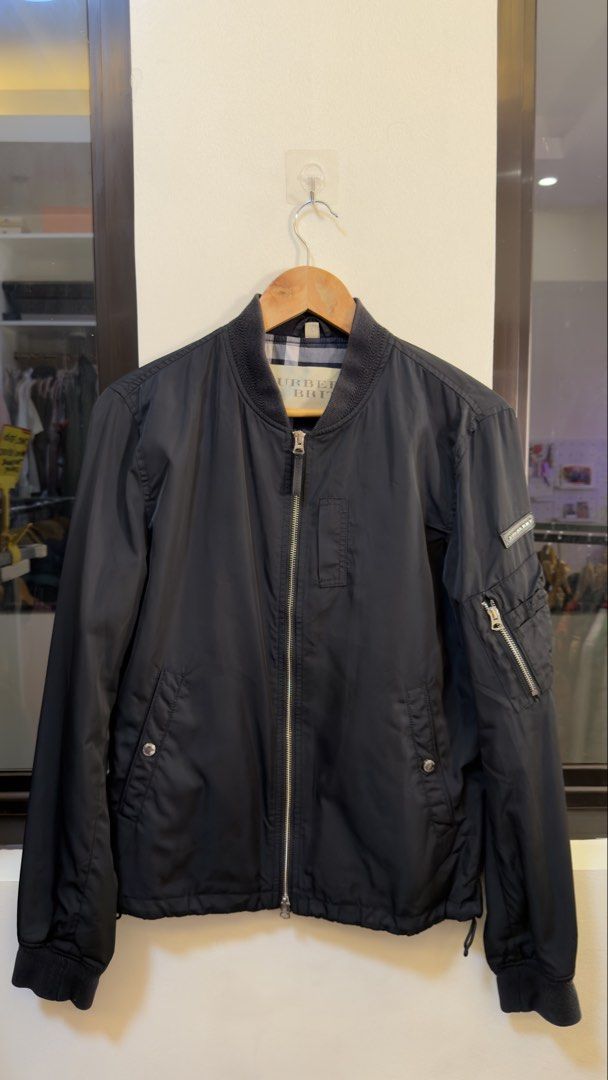 Burberry Brit Black Bomber Jacket (Category: Coats, Jackets and Outerwear) located in Paranaque City. Submitted by preluxeshop_ph (Listing ID 1465551517, Image 2). Description: Burberry Brit Black Bomber Jacket - Color: Solid black - Size: 170/88A - Material: Lightweight polyester and nylon - Design: Full zip front, ribbed collar and cuffs, left sleeve zipper pocket - Detail: Classic Burberry check pattern inner lining.
