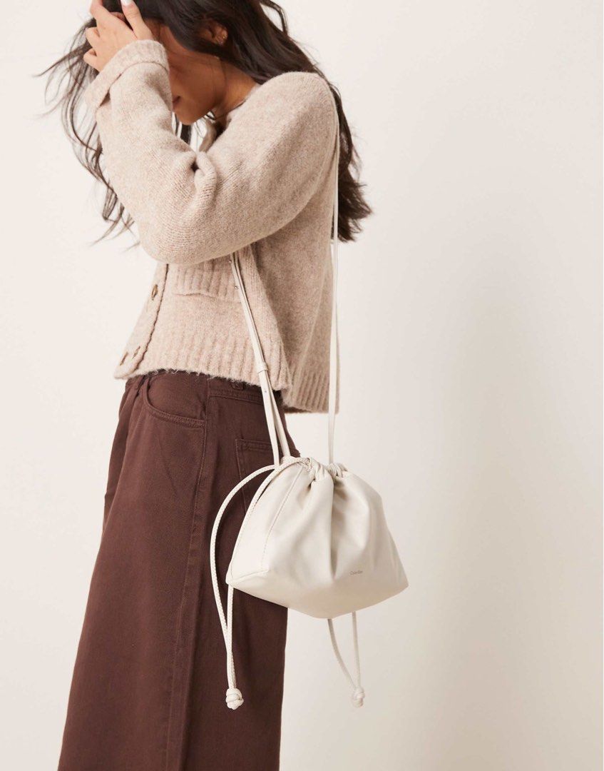 Calvin Klein Jeans White Drawstring Shoulder Bag (Category: Shoulder Bags) located in Quezon City. Submitted by miffysnoop (Listing ID 1465396797, Image 3). Description: - Brand: Calvin Klein Jeans - Color: White - Material: Soft faux leather with subtle front logo lettering - Closure: Drawstring closure - Strap: Adjustable thin strap for crossbody or shoulder wear - Inclusion: Original white Calvin Klein dust bag included - Style: Clean, minimal