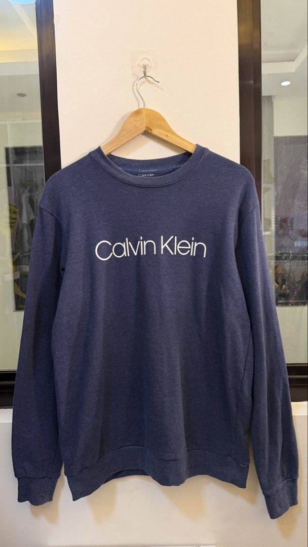 Calvin Klein Navy Blue Logo Sweatshirt Medium (Category: Coats, Jackets and Outerwear) located in Paranaque City. Submitted by preluxeshop_ph (Listing ID 1465558097, Image 2). Description: Calvin Klein Navy Blue Logo Sweatshirt Medium - Color: Navy blue with white chest logo - Size: M (175/95) - Material: Soft cotton blend - Fit: Classic pullover with ribbed cuffs and hem - Condition: Clean, excellent, and ready to wear 🔥CHECK OUT MY PROFILE FOR