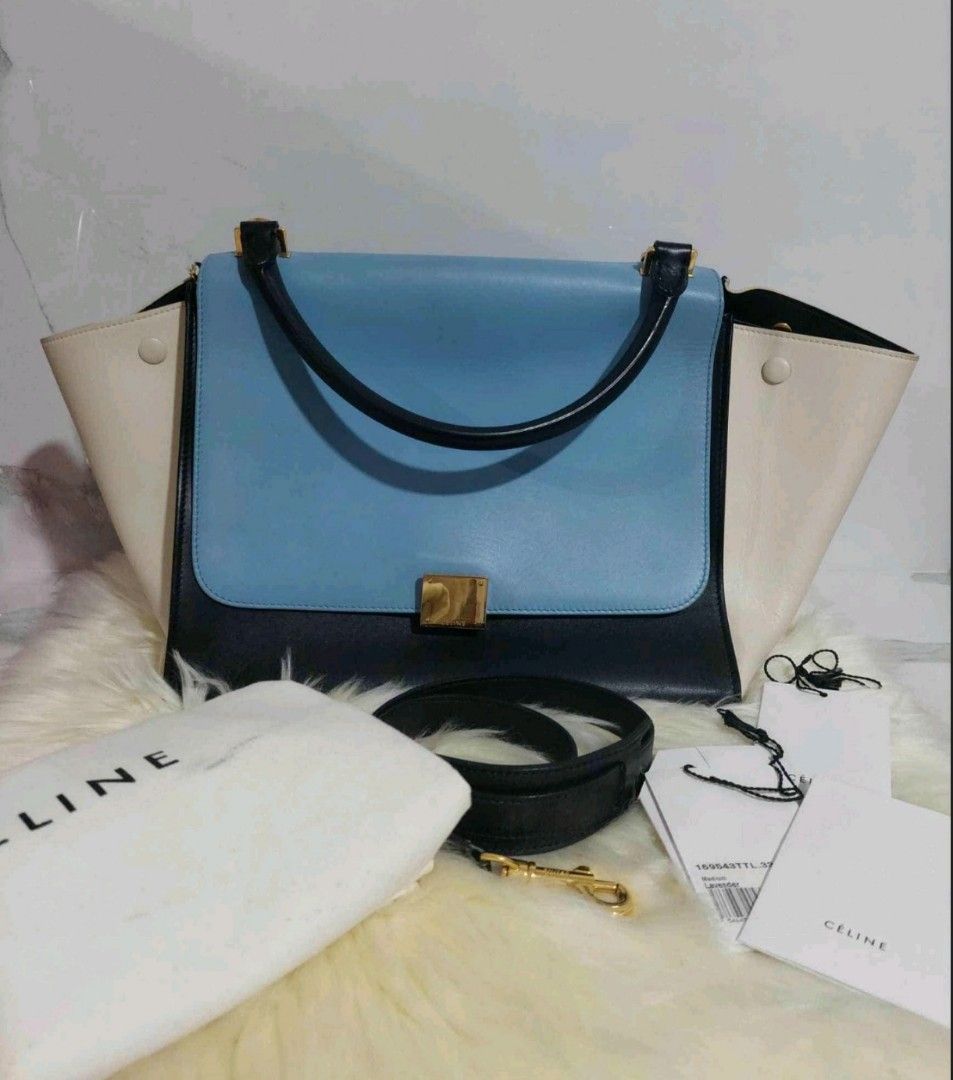 Celine Trapeze Tricolor Leather Bag (Category: Luxury Bags & Wallets) located in Cainta. Submitted by mmusaimports (Listing ID 1465492138, Image 2). Description: - Authentic Celine Trapeze bag in tricolor leather (blue, black, and cream) - Features a rolled top handle and a removable shoulder strap - Gold-tone hardware closure and convenient back zipper pocket - Includes original dust bag and product tags - Meet-ups and shipping available across 