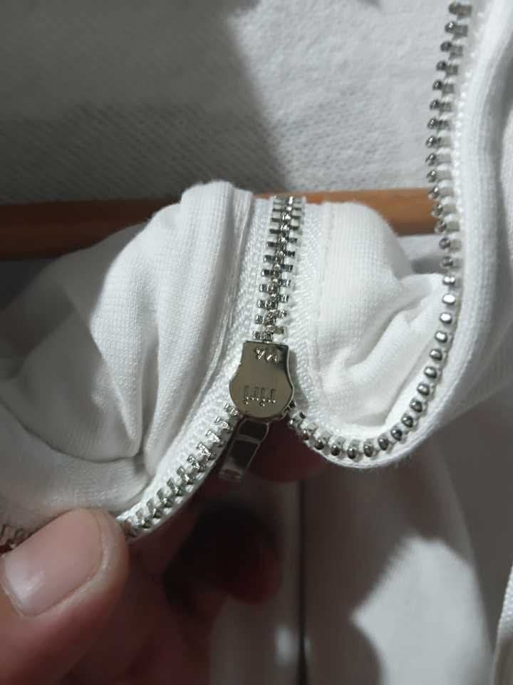 Chanel White Zip Hoodie Size M (Category: Coats, Jackets and Outerwear) located in San Jose. Submitted by garments17 (Listing ID 1465527936, Image 3). Description: - Brand: Chanel - Size: Medium (Made in Italy) - Color: White with striking black and gold floral camellia collage graphics on the back - Features: Smooth full metal zipper closure, drawstring hood, and split kangaroo pockets - Condition: Excellent, ready to wear - Perfect statement pi