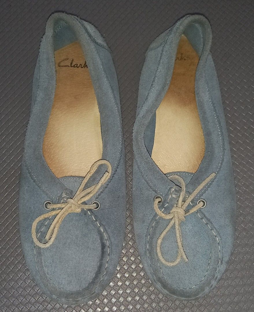 Clarks Blue Suede Moccasin Flats (Category: Loafers) located in Cagayan de Oro. Submitted by edwardryan01984 (Listing ID 1465416942, Image 1). Description: - Brand: Clarks - Style: Light blue suede slip-on shoes with front tie detail - Origin: Made in Portugal - Size: UK/US 5 - Features: Flat soles with a slight heel, comfortable leather insoles (note: insoles show visible wear) - Condition: Pre-loved, well-kept.