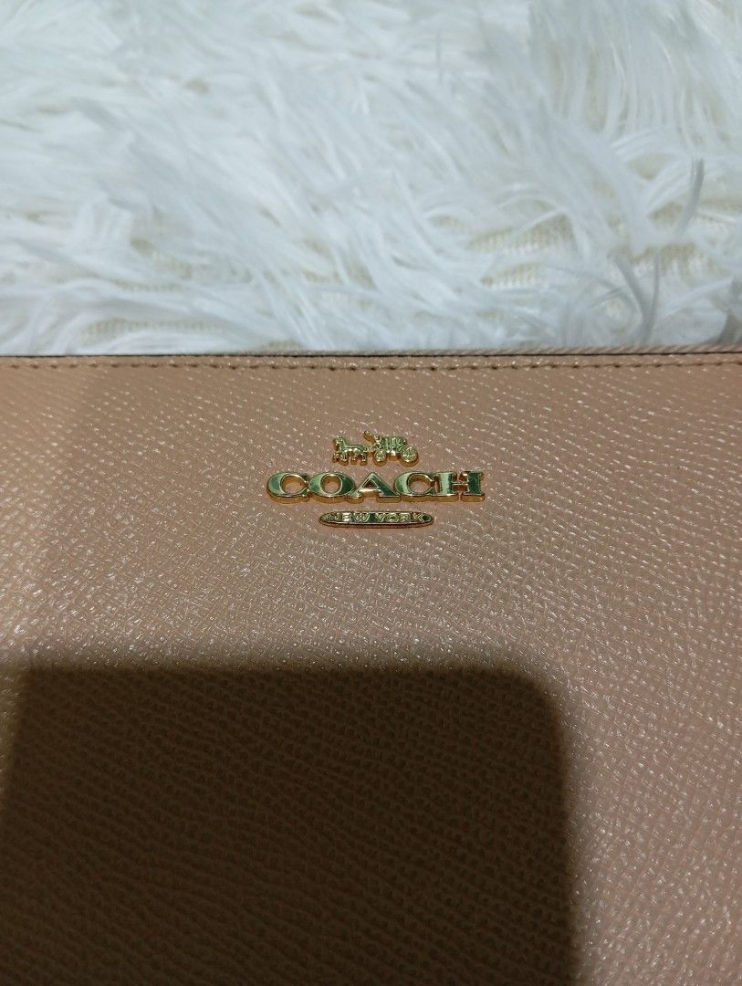 Coach Beige Crossgrain Leather Zip Around Wallet (Category: Luxury Bags & Wallets) located in Quezon City. Submitted by thesecondmarketph (Listing ID 1465440719, Image 2). Description: - Authentic Coach zip around wallet in a versatile soft beige crossgrain leather - Elegant gold-tone hardware and zipper pull with embossed Coach logo - Interior includes multiple card slots, slip pockets, and a secure zippered coin compartment - Style number 57713