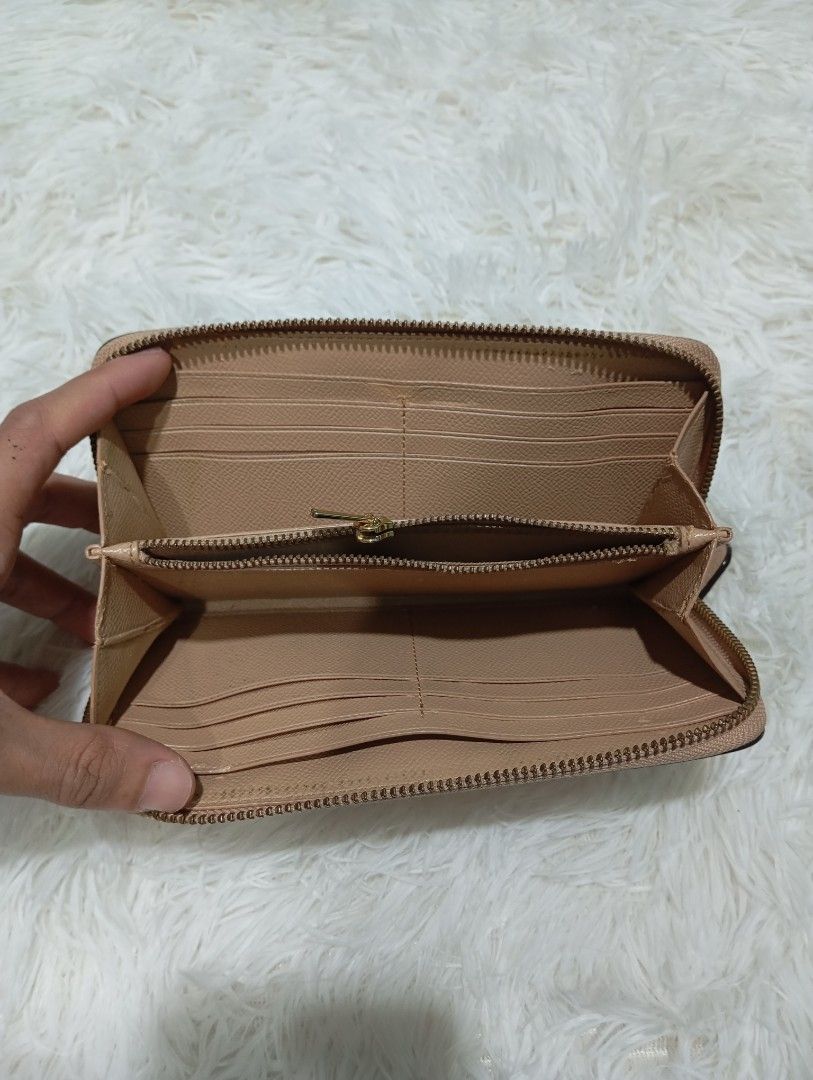 Coach Beige Crossgrain Leather Zip Around Wallet (Category: Luxury Bags & Wallets) located in Quezon City. Submitted by thesecondmarketph (Listing ID 1465440719, Image 3). Description: - Authentic Coach zip around wallet in a versatile soft beige crossgrain leather - Elegant gold-tone hardware and zipper pull with embossed Coach logo - Interior includes multiple card slots, slip pockets, and a secure zippered coin compartment - Style number 57713