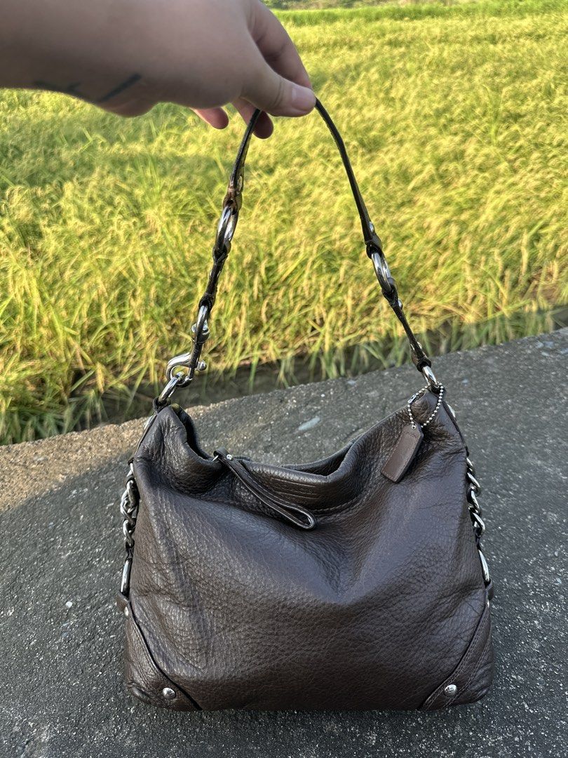 Coach Carly Choco Brown Medium Size with Silver Hardware (Category: Luxury Bags & Wallets) located in Manila. Submitted by glesylbd_22 (Listing ID 1465396881, Image 1). Description: - Brand: Coach - Style: Leather hobo bag - Color: Dark brown with pebbled texture - Hardware: Silver-tone links and accents - Closure: Secure zip top - Inclusions: Matching hangtag on a beaded chain - Interior: Clean lining - Condition: Good everyday size, well-mainta