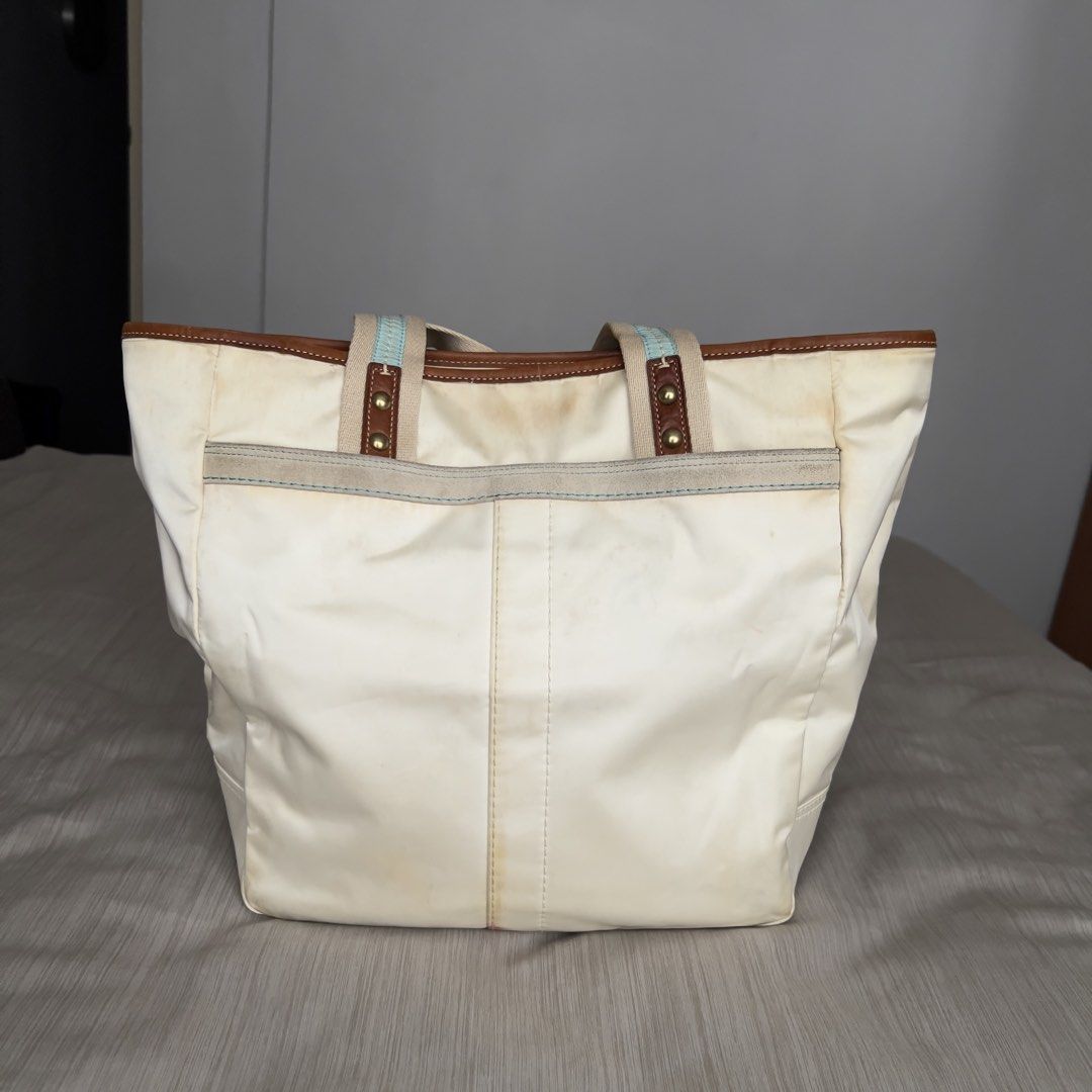 COACH Hamptons White Satin Tote Bag (Category: Luxury Bags & Wallets) located in Pasig City. Submitted by jenscloset86 (Listing ID 1465456255, Image 3). Description: COACH Hamptons White Satin Tote Bag Measurement (in inches): Height: 12.5” Length: 17” Bottom wodth: 4.75” Handle: 17.5” • Authentic Coach Hamptons tote bag in white satin fabric, - Features tan leather trim and brass hardware accents with double shoulder straps. • Exterior fabric ha