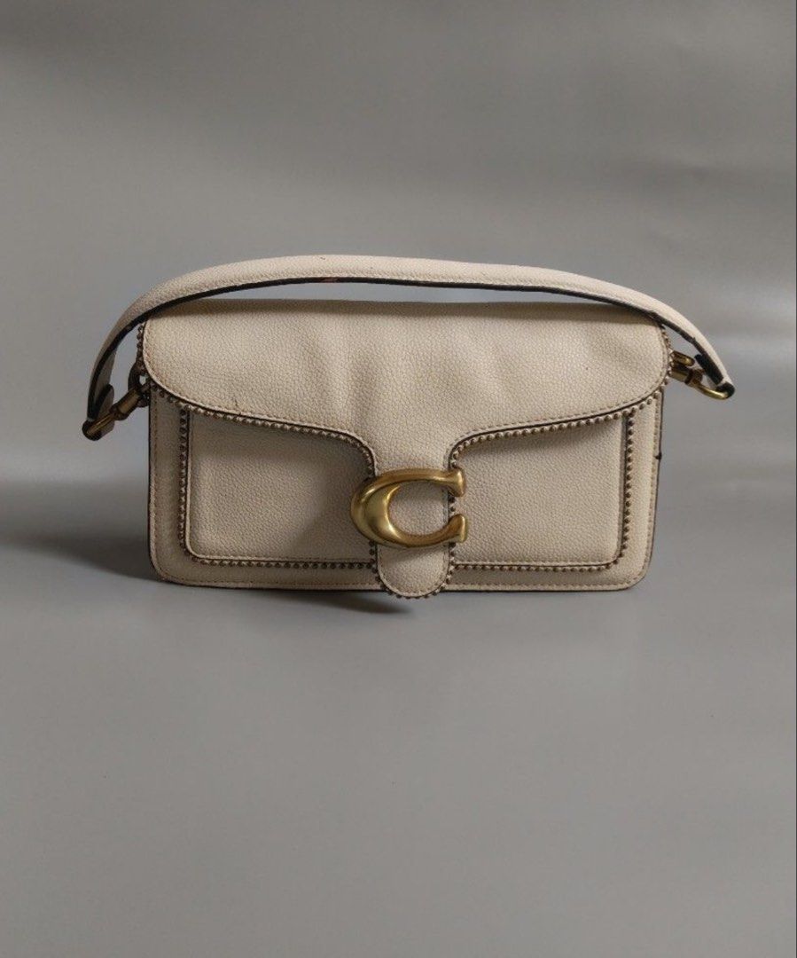 Coach Tabby Shoulder Bag White With Brass Hardware (Category: Luxury Bags & Wallets) located in Makati City. Submitted by kaydecluttersss (Listing ID 1465387132, Image 1). Description: - Brand: Coach - Style: Structured shoulder bag with top handle with detachable shoulder strap - Material: Off-white pebble grain leather with luxurious brown suede lining - Hardware: Antiqued brass with signature C pushlock closure and bead chain trim - Interior: 