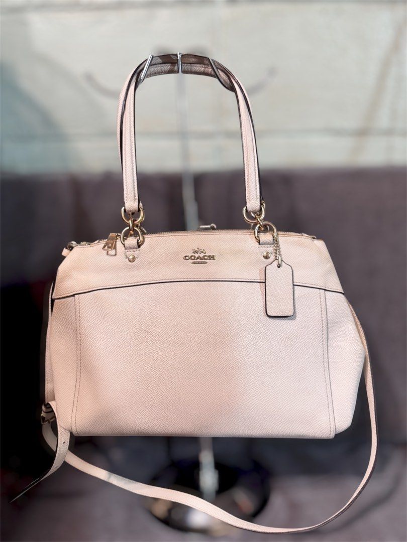 Coach white Leather Shoulder Bag Satchel (Category: Luxury Bags & Wallets) located in Manila. Submitted by dearpinkcollections (Listing ID 1465435295, Image 1). Description: - Brand: Coach - Color: white with dark brown interior lining - Material: Genuine leather with gold-tone hardware - Features: Dual top handles, detachable shoulder strap, secure zipper closure, multiple compartments, and slip pockets - Inclusions: Original Coach hangtag - Con