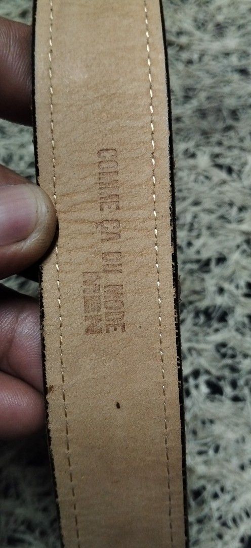 COMME CA DU MODE Men pure Black Leather Belt (Category: Belts) located in Paranaque City. Submitted by michael-08 (Listing ID 1465390369, Image 2). Description: - Brand: Comme Ca Du Mode Men - Material: Genuine black leather with tan inner lining - Design: Stitched edges and silver-tone rectangular buckle - Condition: Visible scratches on the buckle from regular wear - Features: Multiple adjustment holes for a customized fit - Style: Classic ever