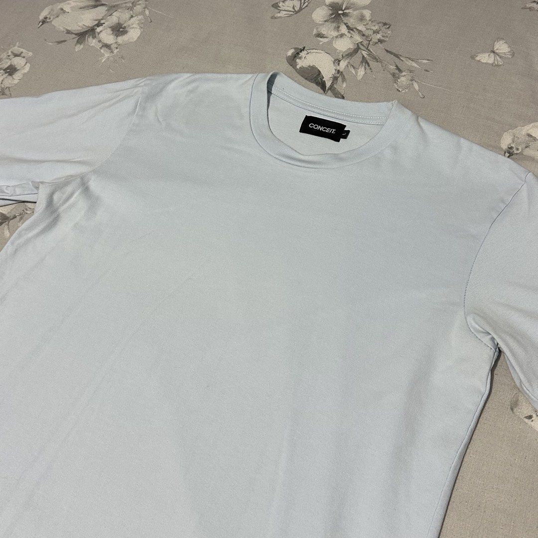 CONCEIT Light Blue Casual T-Shirt (Category: Tshirts & Polo Shirts ) located in Lipa City. Submitted by jecoparra (Listing ID 1465508838, Image 2). Description: - Brand: CONCEIT - Color: Light blue (plain, no prints/graphics) - Fit: Relaxed crew neck with short sleeves - Material: Soft, medium-weight fabric - Condition/Environment: Great everyday basic tee from a smoke-free home.