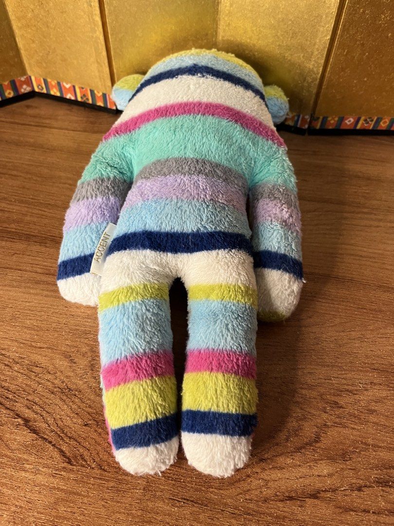 Craftholic Multi-colored Striped Plush (Category: Plushies & Soft Toys) located in Gapan. Submitted by lunashop14 (Listing ID 1465562055, Image 3). Description: - Authentic Craftholic plush toy with adorable multi-colored horizontal stripes (pink, blue, green, white, and purple) - Made with a super soft and cuddly texture, perfect for hugging or resting - Features an Accent brand tag on the side and official Craftholic tag on the front arm - Vers