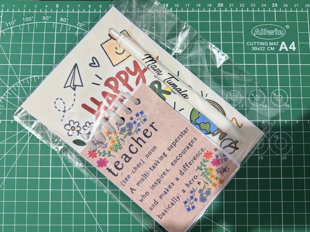 Custom Notepad and Pen Gift Set (Category: Stationery & School Supplies) located in Manila. Submitted by kitbizshop2026 (Listing ID 1465483855, Image 2). Description: Personalized teacher appreciation sets in clear plastic packaging. Each set includes a custom notepad with names like Mam Tumala, Mam Nida, Mam Chris, Cel, and Sir Rodel printed on the cover, plus a matching white pen. Cute floral designs and teacher quotes included. Great giveaway 