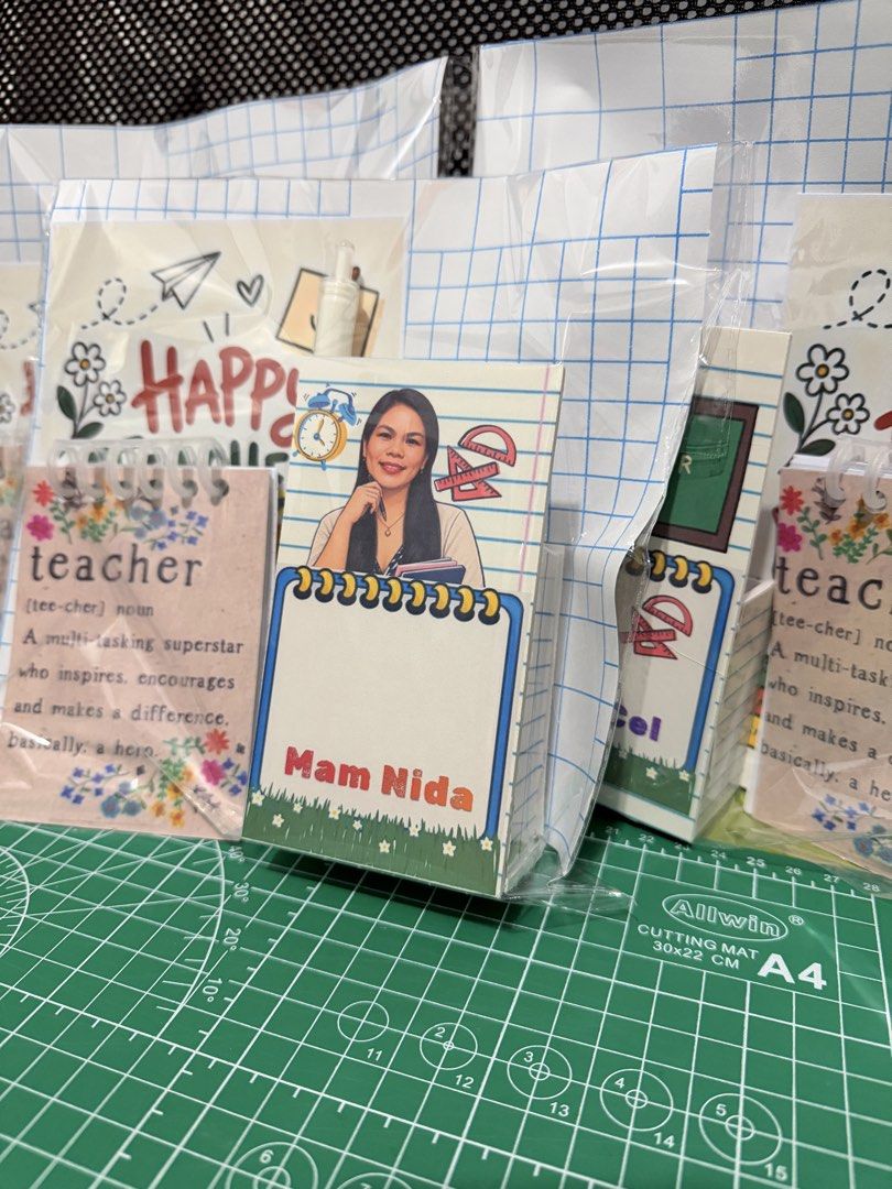 Custom Notepad and Pen Gift Set (Category: Stationery & School Supplies) located in Manila. Submitted by kitbizshop2026 (Listing ID 1465483855, Image 3). Description: Personalized teacher appreciation sets in clear plastic packaging. Each set includes a custom notepad with names like Mam Tumala, Mam Nida, Mam Chris, Cel, and Sir Rodel printed on the cover, plus a matching white pen. Cute floral designs and teacher quotes included. Great giveaway 