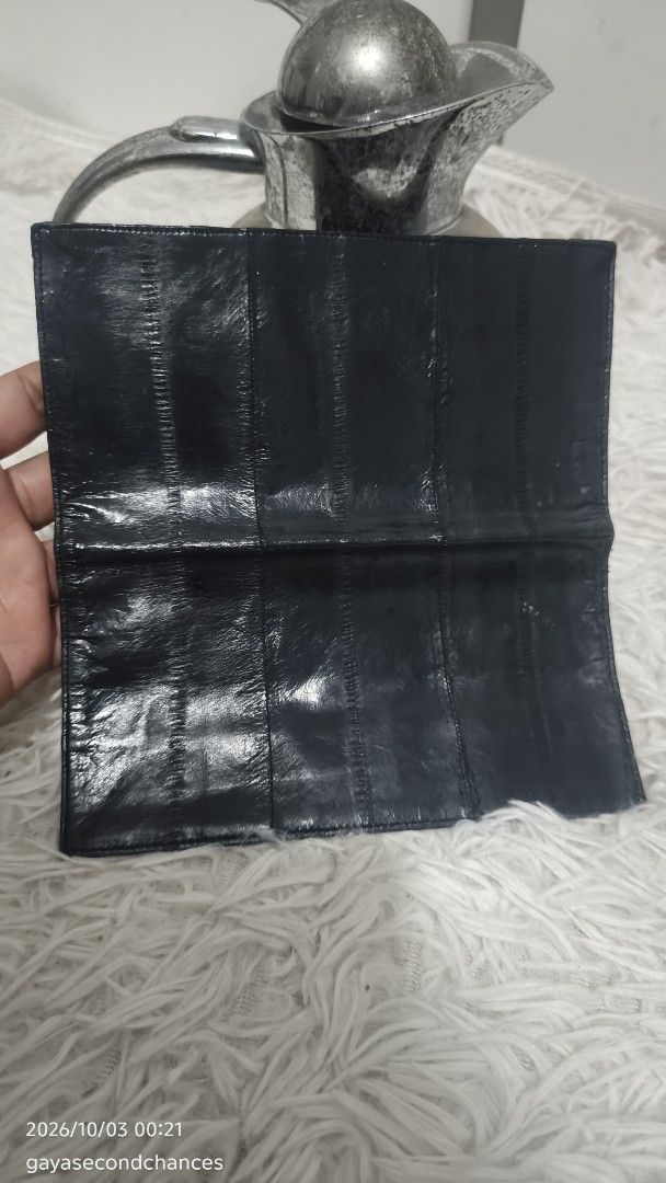 DARK BLUE E EL SKIN LEATHER CHECK BOOK WALLET (Category: Wallets & Card holders) located in Kalibo. Submitted by secondchances.thriftsh8p (Listing ID 1465536693, Image 3). Description: - Color & Finish: Sleek black with a clean dark finish. - Missing zipper puller. - Material: Premium textured panel leather - Design: Slim rectangular shape with stylish stitched vertical segments - Functionality: Multiple slots and compartments for everyday organi