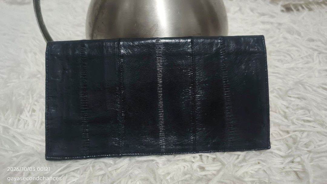 DARK BLUE E EL SKIN LEATHER CHECK BOOK WALLET (Category: Wallets & Card holders) located in Kalibo. Submitted by secondchances.thriftsh8p (Listing ID 1465536693, Image 1). Description: - Color & Finish: Sleek black with a clean dark finish. - Missing zipper puller. - Material: Premium textured panel leather - Design: Slim rectangular shape with stylish stitched vertical segments - Functionality: Multiple slots and compartments for everyday organi