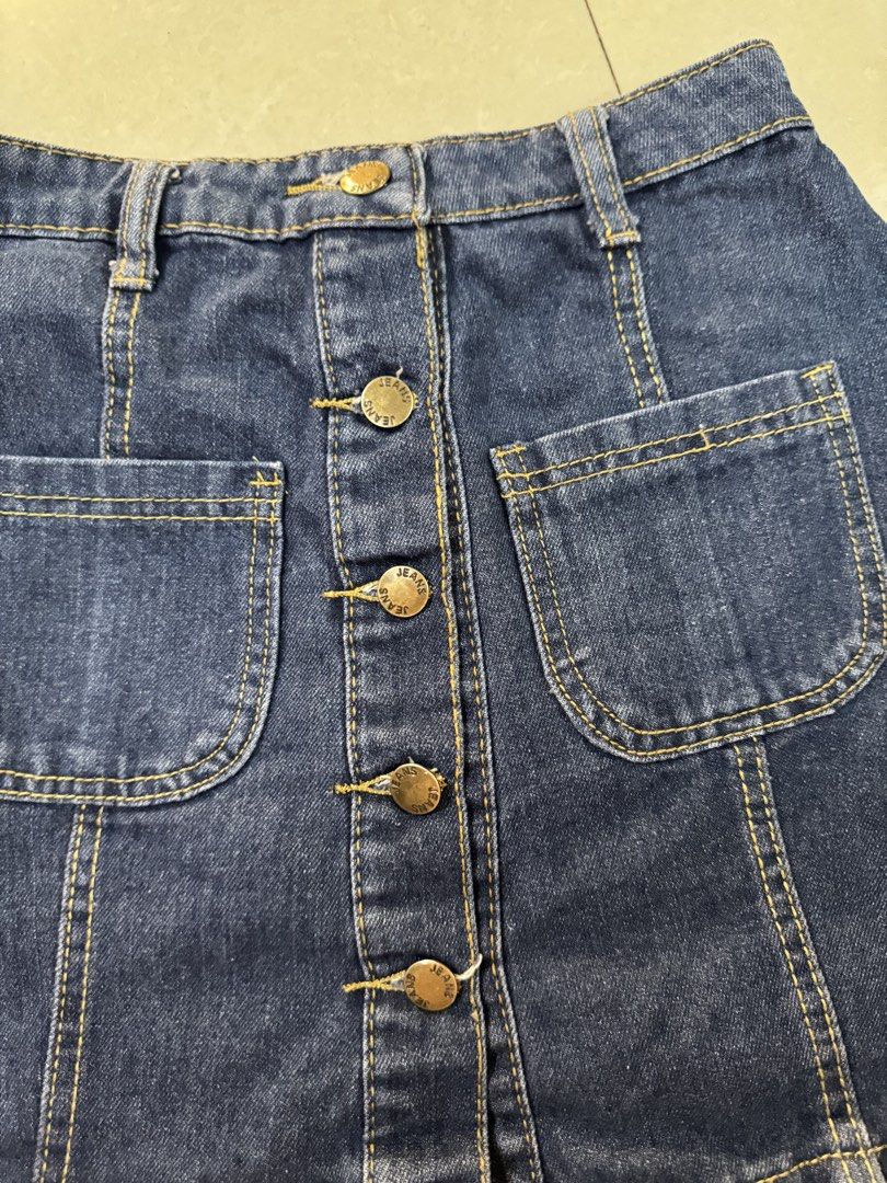 Datk Blue denim skirt with 2 front pockets (Category: Skirts) located in Quezon City. Submitted by sweetlyluxe (Listing ID 1465481836, Image 2). Description: - Color/Material: Classic blue denim - Closure: Front button-up with brass hardware - fits small - Details: belt loops, and two utility front pockets - Fit: Comfortable elastic waistband in the back - Style: Simple, versatile basic piece perfect for casual everyday outfits.