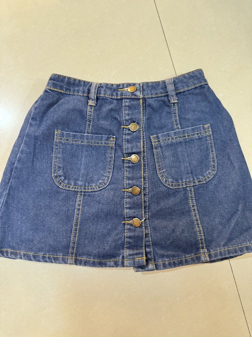 Datk Blue denim skirt with 2 front pockets (Category: Skirts) located in Quezon City. Submitted by sweetlyluxe (Listing ID 1465481836, Image 1). Description: - Color/Material: Classic blue denim - Closure: Front button-up with brass hardware - fits small - Details: belt loops, and two utility front pockets - Fit: Comfortable elastic waistband in the back - Style: Simple, versatile basic piece perfect for casual everyday outfits.