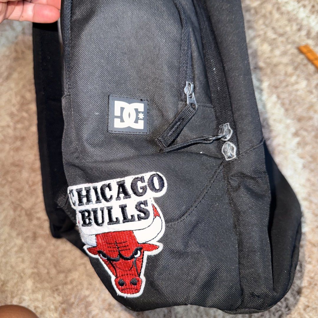 DC Shoes USA Black Backpack (Category: Backpacks) located in Daraga. Submitted by sudeboy031092 (Listing ID 1465492376, Image 3). Description: - Brand: DC Shoes USA - Color: Black with white DC logo patch and Chicago Bulls side patch - Size: Approx. 18" tall x 16" wide - Storage: Spacious main compartment, inner organizational sleeves, multiple zippered compartments, and side pockets - Condition: Excellent everyday bag - Ideal for: School, skateb