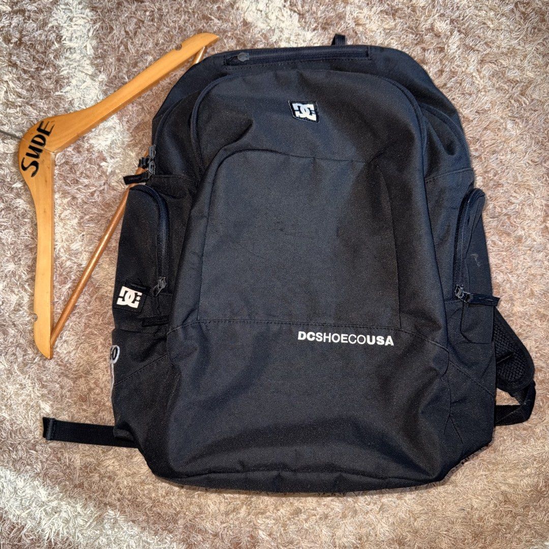 DC Shoes USA Black Backpack (Category: Backpacks) located in Daraga. Submitted by sudeboy031092 (Listing ID 1465492376, Image 1). Description: - Brand: DC Shoes USA - Color: Black with white DC logo patch and Chicago Bulls side patch - Size: Approx. 18" tall x 16" wide - Storage: Spacious main compartment, inner organizational sleeves, multiple zippered compartments, and side pockets - Condition: Excellent everyday bag - Ideal for: School, skateb