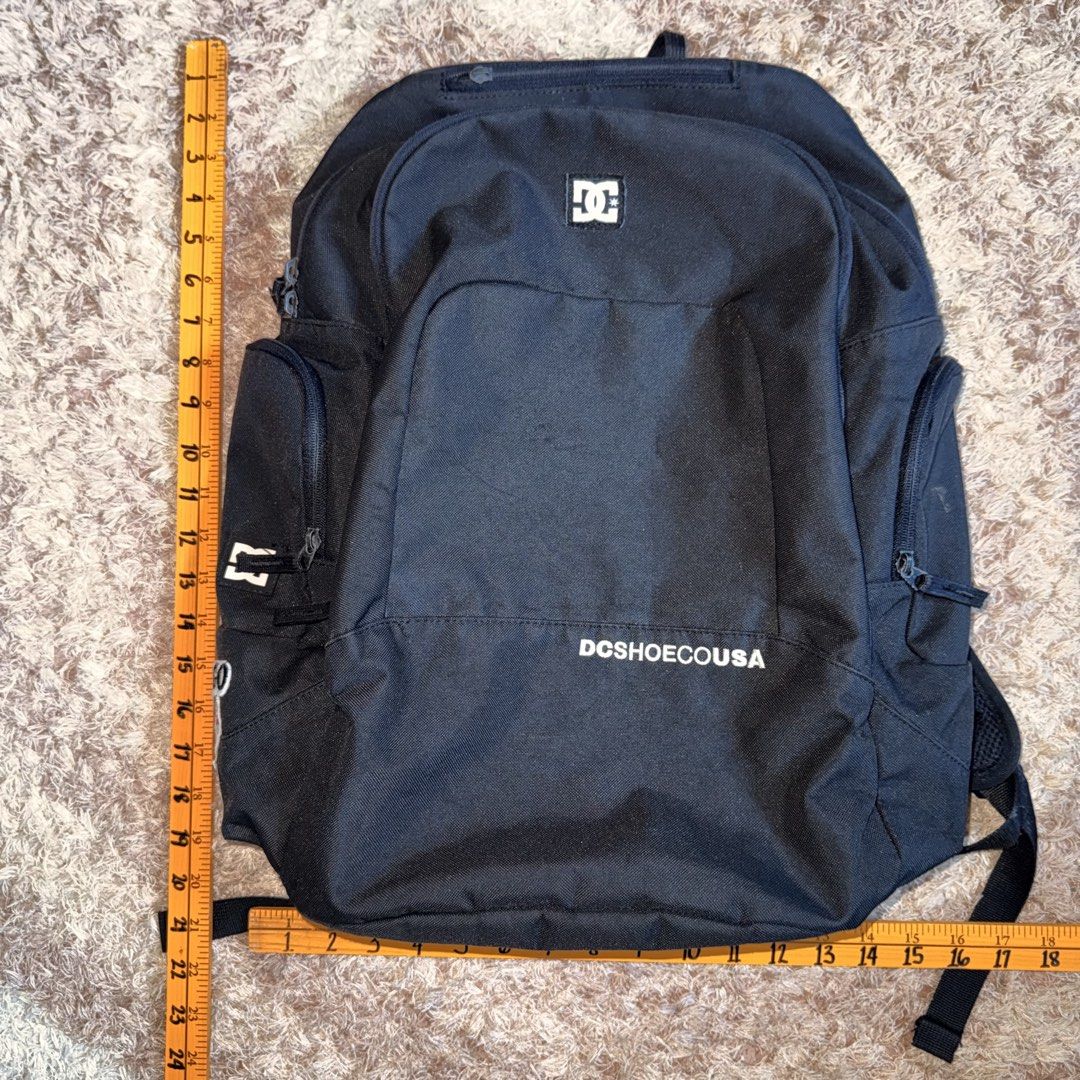 DC Shoes USA Black Backpack (Category: Backpacks) located in Daraga. Submitted by sudeboy031092 (Listing ID 1465492376, Image 2). Description: - Brand: DC Shoes USA - Color: Black with white DC logo patch and Chicago Bulls side patch - Size: Approx. 18" tall x 16" wide - Storage: Spacious main compartment, inner organizational sleeves, multiple zippered compartments, and side pockets - Condition: Excellent everyday bag - Ideal for: School, skateb