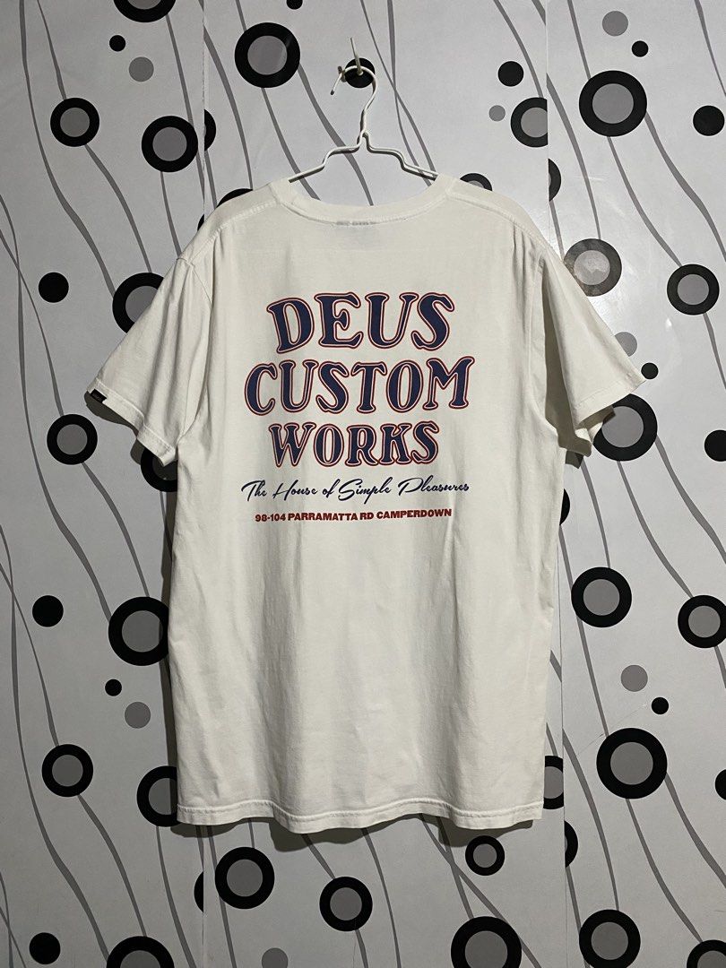 Deus Ex Machina Works Tee (Category: Tshirts & Polo Shirts ) located in Cebu City. Submitted by patspickph (Listing ID 1465424281, Image 1). Description: This is a white Deus Ex Machina Works Tee with a retro graphic on the back and also a print Logo on the Front . Size XL on tag Fits L aswell dimensions W22.5 L30.5 Excellent Condition.