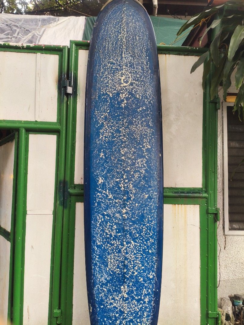 Dewey Weber Longboard Surfboard Blue (Category: Water Sports) located in Manila. Submitted by tonio124 (Listing ID 1465453001, Image 1). Description: - Brand/Model: Dewey Weber classic longboard in deep blue - Design: Features the iconic 'stay close to the soul' logo near the center stringer - Condition: Shows minor dings, pressure bumps, and wax buildup from regular use - Performance: Perfect for smooth wave cruising Board Bag Included - Status: