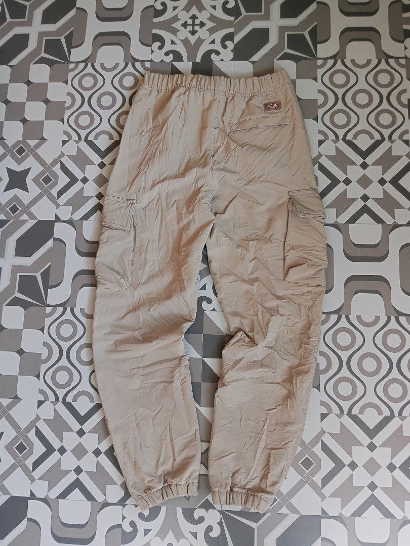 Dickies Beige Cargo Pants with Integrated Belt (Category: Trousers) located in Lingayen. Submitted by rahzzelula73279 (Listing ID 1465450228, Image 3). Description: - Brand: Dickies - Color: Beige - Fit: Regular fit with zipper fly closure - Material: 92% polyester, 8% elastane blend for comfort and flexibility - Features: Built-in black web belt with buckle closure - Details: Elastic waistband and ankle cuffs - Storage: Multiple side cargo pocke