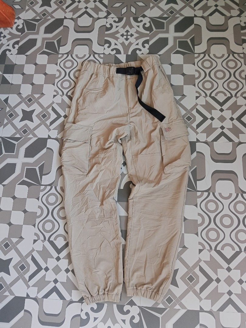 Dickies Beige Cargo Pants with Integrated Belt (Category: Trousers) located in Lingayen. Submitted by rahzzelula73279 (Listing ID 1465450228, Image 1). Description: - Brand: Dickies - Color: Beige - Fit: Regular fit with zipper fly closure - Material: 92% polyester, 8% elastane blend for comfort and flexibility - Features: Built-in black web belt with buckle closure - Details: Elastic waistband and ankle cuffs - Storage: Multiple side cargo pocke