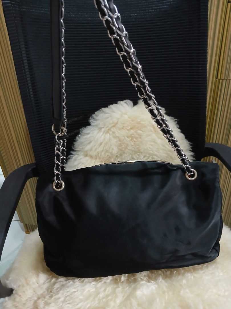 Black Shoulder Bag with Chain Strap (Category: Shoulder Bags) located in Taguig. Submitted by demsclosetph (Listing ID 1465429737, Image 3). Description: - Material: Durable black nylon with leather details - Hardware: Signature silver-tone oversized 'D' logo on front - Strap: Combined leather and chain shoulder strap with silver links - Closure: Side buckle detail - Interior: Roomy main compartment for everyday essentials - Condition: Clean fabr