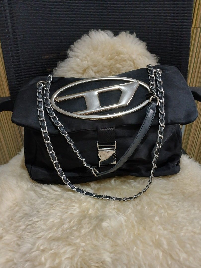 Black Shoulder Bag with Chain Strap (Category: Shoulder Bags) located in Taguig. Submitted by demsclosetph (Listing ID 1465429737, Image 2). Description: - Material: Durable black nylon with leather details - Hardware: Signature silver-tone oversized 'D' logo on front - Strap: Combined leather and chain shoulder strap with silver links - Closure: Side buckle detail - Interior: Roomy main compartment for everyday essentials - Condition: Clean fabr
