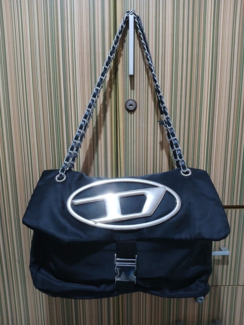 Black Shoulder Bag with Chain Strap (Category: Shoulder Bags) located in Taguig. Submitted by demsclosetph (Listing ID 1465429737, Image 1). Description: - Material: Durable black nylon with leather details - Hardware: Signature silver-tone oversized 'D' logo on front - Strap: Combined leather and chain shoulder strap with silver links - Closure: Side buckle detail - Interior: Roomy main compartment for everyday essentials - Condition: Clean fabr