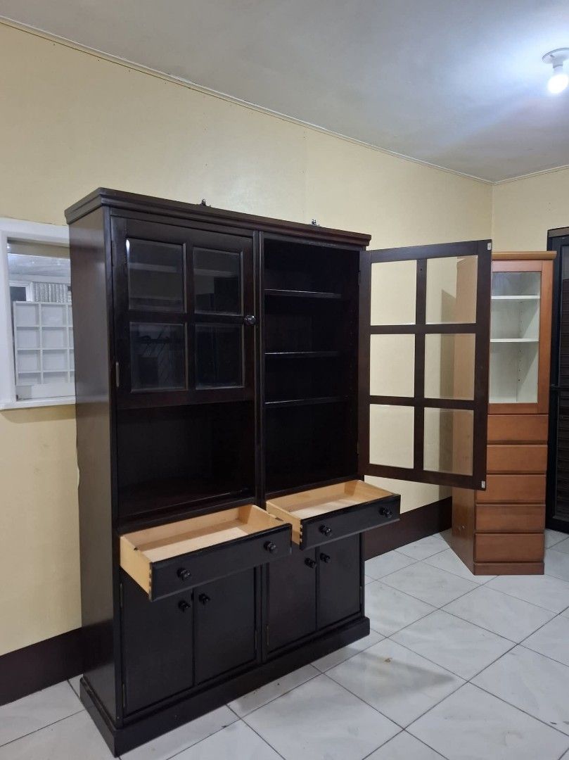 Display Hutch Storage Cabinet Platera Bookcase (Category: Shelves, Cabinets & Racks) located in Quezon City. Submitted by dannikkishoppe2 (Listing ID 1465385085, Image 3). Description: Display Hutch Storage Cabinet Platera Bookcase‼️₱11000‼️ • Finish: Deep brown with visible wood joinery • Dimensions: 46.5"L x 14.5"W x 70.75"H • Upper Section: Glass-paneled doors with interior shelves for display • Middle Section: Two functional pull-out drawers 