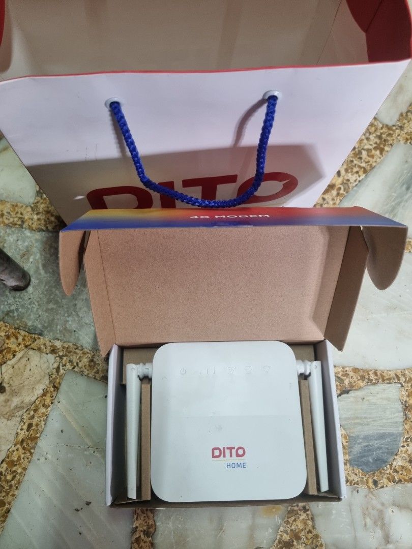 Dito Home 4G Modem Wireless Router (Category: Networking) located in Manila. Submitted by monya111 (Listing ID 1465400468, Image 2). Description: - Brand new, unused Dito Home wireless router - Sleek white casing with dual external antennas - Status indicator icons and official Dito logo on the front - Comes complete in the original brown cardboard box - Includes a branded Dito carrier paper bag - Stored safely inside protective paper inserts.