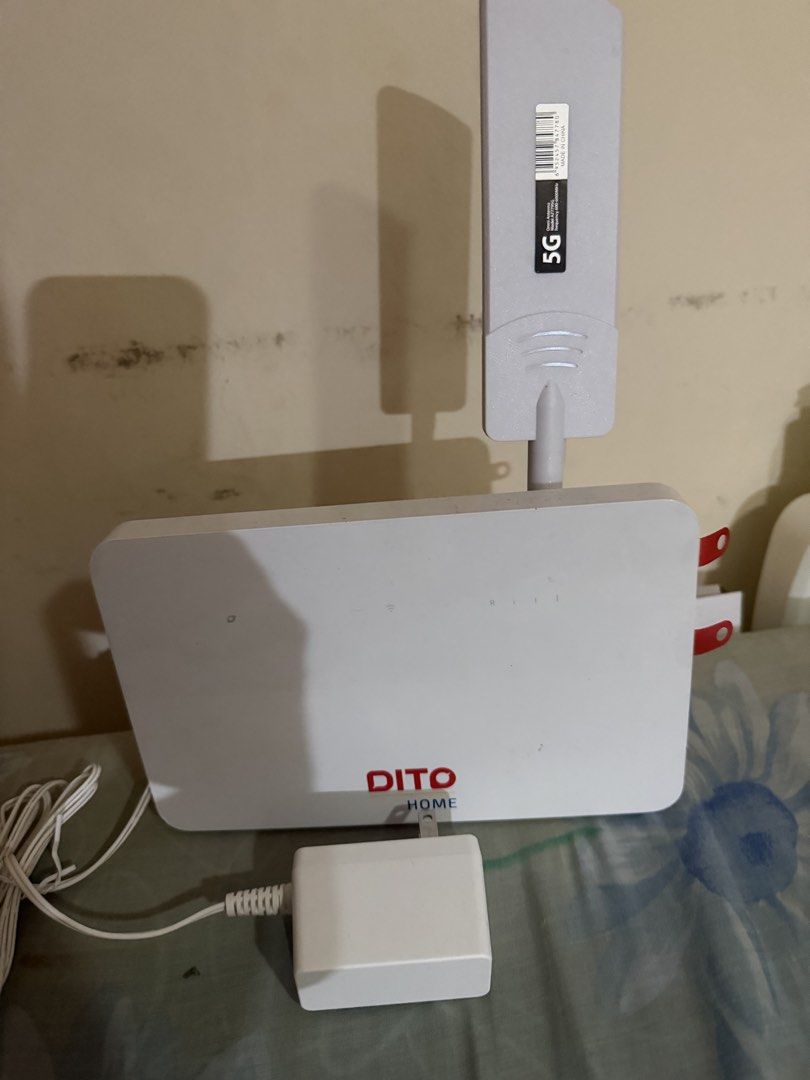 DITO Home 5G Wireless Router with Antenna (Category: Networking) located in Paranaque City. Submitted by mryjwll (Listing ID 1465439178, Image 2). Description: - Model: DITO Home 5G Router in clean white housing - Includes attached 5G omni antenna on top for better signal - Comes complete with power adapter block and long white cable - Features intact red pull tabs on side port covers - 100% clean unit and ready for instant home internet connecti