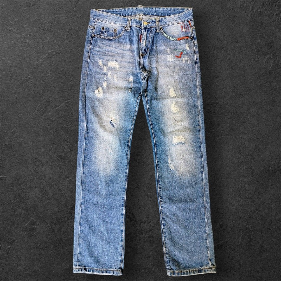 Dsquared2 Distressed Denim Jeans (Category: Jeans) located in Manila. Submitted by gerald_quinto (Listing ID 1465476425, Image 2). Description: - Brand: Dsquared2 -Size 34 -Length 42 -Hem 7.5 - Wash: Light wash with intentional distressing, faded areas, and minor rips - Accents: Unique multi-colored stitching near the front pocket and fly - Hardware: Branded metal button closure and signature red logo tab - Details: Leather patch with embroidered