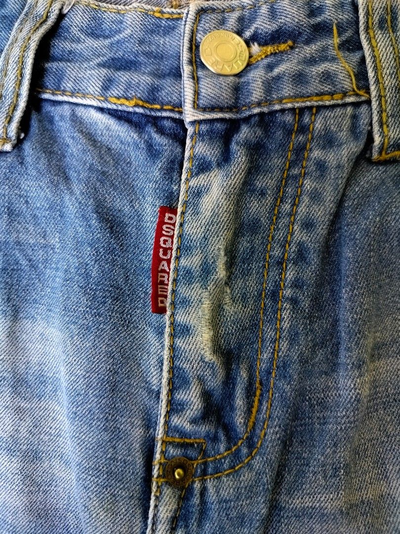Dsquared2 Distressed Denim Jeans (Category: Jeans) located in Manila. Submitted by gerald_quinto (Listing ID 1465476425, Image 3). Description: - Brand: Dsquared2 -Size 34 -Length 42 -Hem 7.5 - Wash: Light wash with intentional distressing, faded areas, and minor rips - Accents: Unique multi-colored stitching near the front pocket and fly - Hardware: Branded metal button closure and signature red logo tab - Details: Leather patch with embroidered