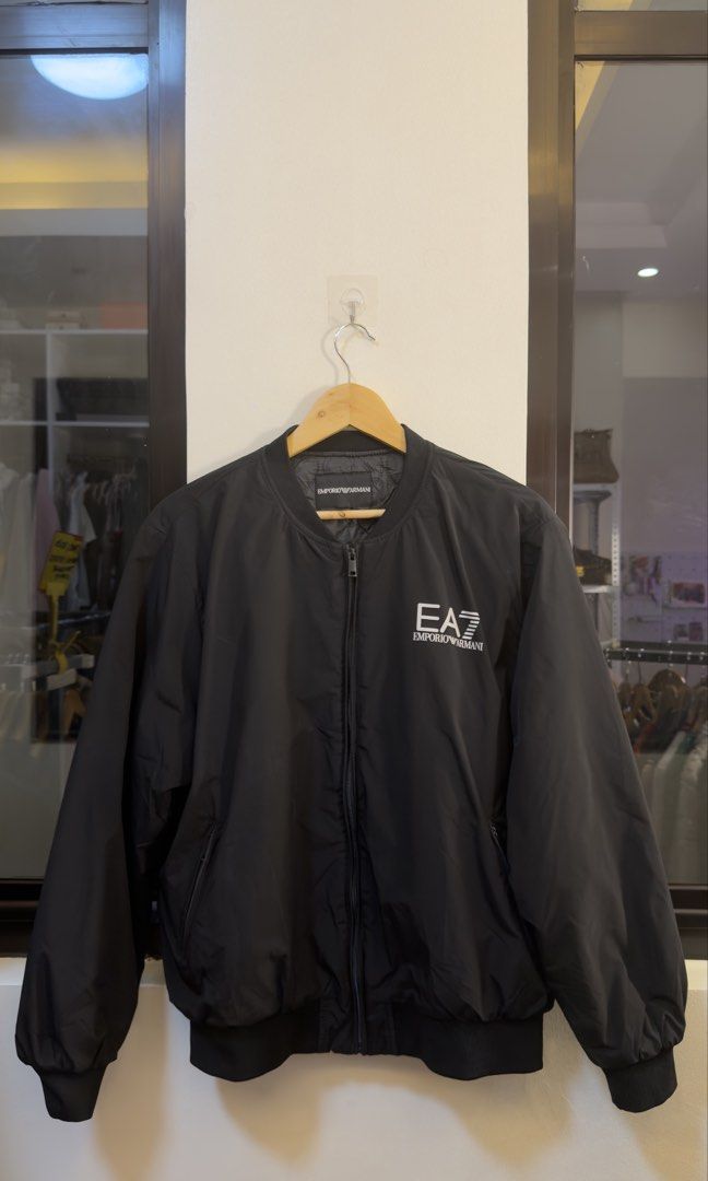 EA7 Emporio Armani Black Bomber Jacket (Category: Coats, Jackets and Outerwear) located in Paranaque City. Submitted by preluxeshop_ph (Listing ID 1465549463, Image 2). Description: EA7 Emporio Armani Black Bomber Jacket - Color: Black with white branding - Style: Bomber jacket with full zip front - Details: White EA7 logo on chest, large embroidered MILANO text on back shoulders - Interior: Quilted inner lining with branded neck tag - Fit/Feel: 