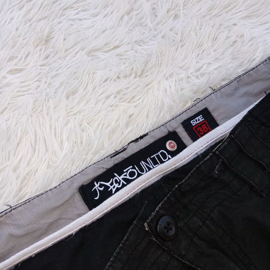 Ecko Unltd Black Cargo Shorts Size 38 (Category: Shorts) located in Gattaran. Submitted by thrift_wiseph (Listing ID 1465452598, Image 3). Description: - Brand: Ecko Unltd - Size: 38 waist - Color: Black - Style: Streetwear cargo shorts - Pockets: Multiple utility pockets on sides and back - Details: Large rhino graphic print on the right back pocket - Fit adjustments: Adjustable side waist buckles and snap button hems.