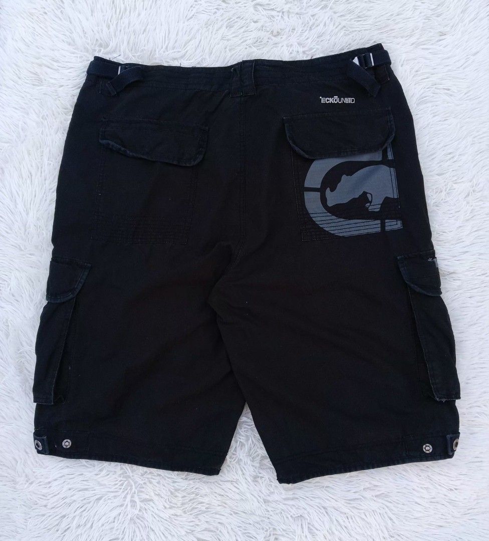 Ecko Unltd Black Cargo Shorts Size 38 (Category: Shorts) located in Gattaran. Submitted by thrift_wiseph (Listing ID 1465452598, Image 1). Description: - Brand: Ecko Unltd - Size: 38 waist - Color: Black - Style: Streetwear cargo shorts - Pockets: Multiple utility pockets on sides and back - Details: Large rhino graphic print on the right back pocket - Fit adjustments: Adjustable side waist buckles and snap button hems.