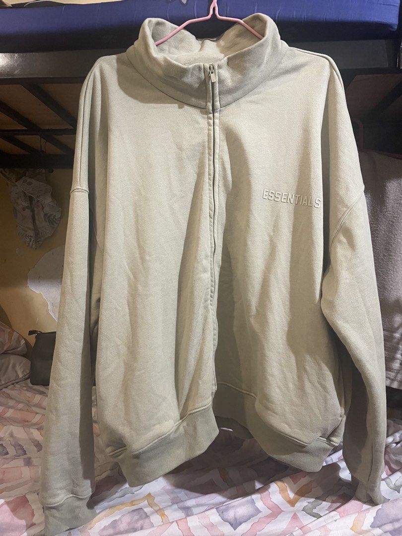 Essentials Juice Full Zip Mock Neck Sweatshirt (Category: Activewear) located in Manila. Submitted by jabjabthriftplace (Listing ID 1465473130, Image 1). Description: - Brand: Essentials Juice - Color: Sage Green - Size: Small (tag attached) - Material: 100% Cotton - Design: Full-zip with mock neck, vertical chest branding, and back collar rubber logo patch - Condition: Brand new with tags.